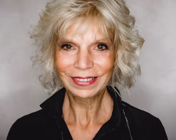 Older blond woman with shorter hair smiling into the camera