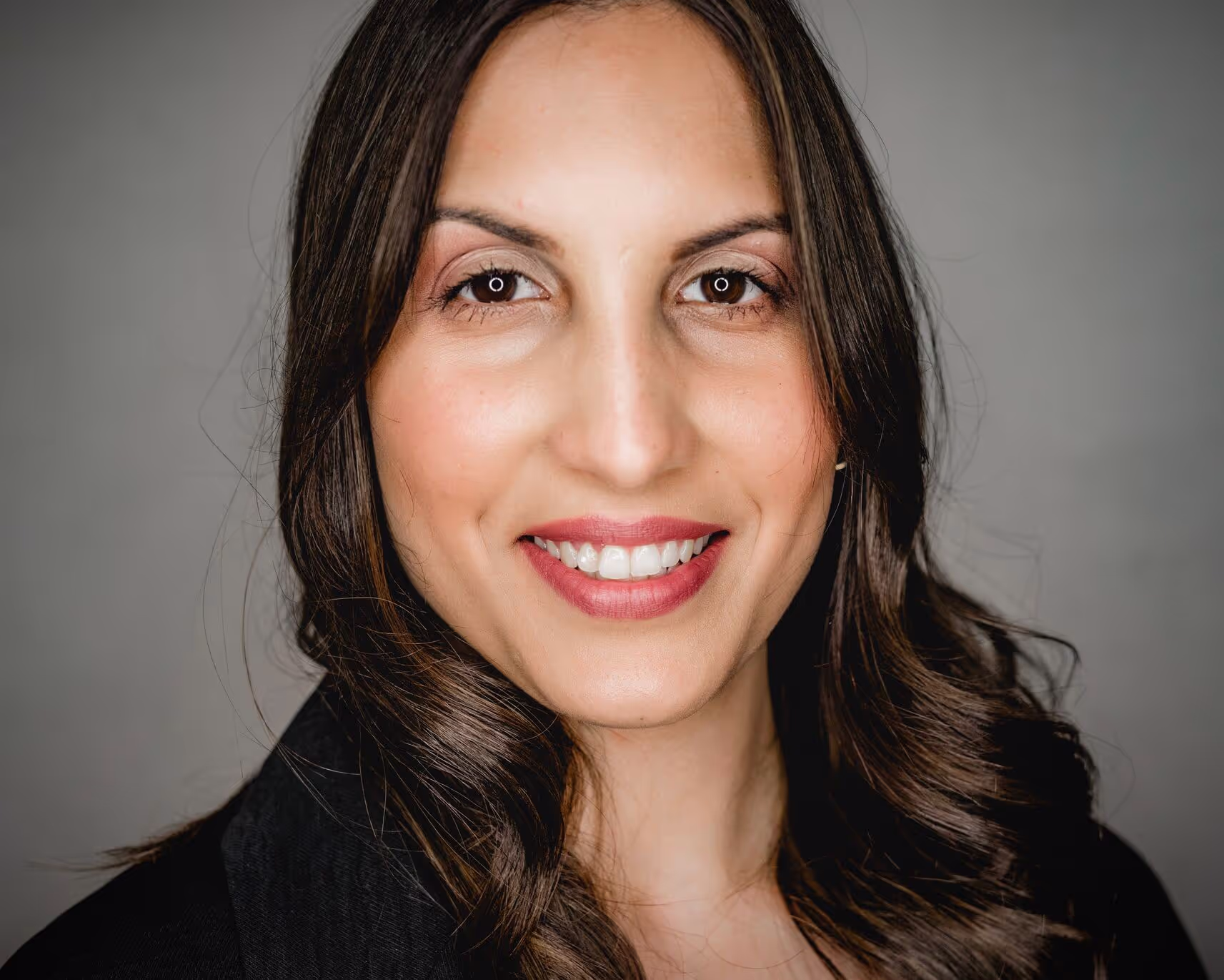 Woman wit brown hair and eyes smiling directly into the camera